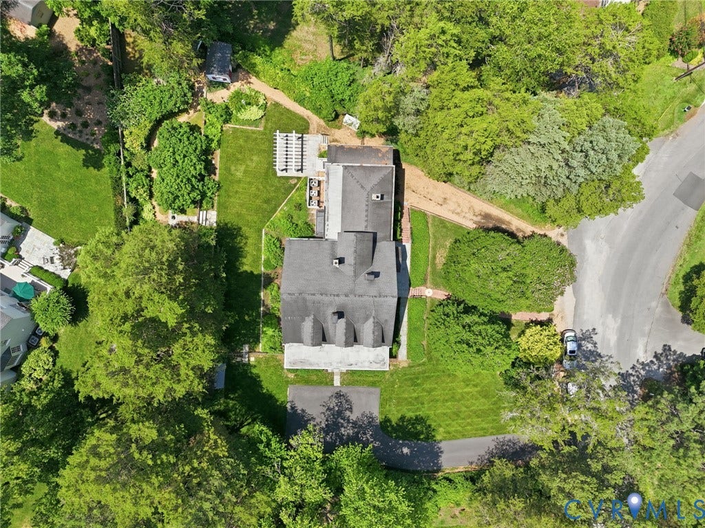Expansive property featuring mature trees, landscaped green space, and paved driveways