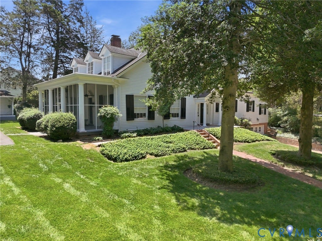 White exterior with black shutters and a screened porch