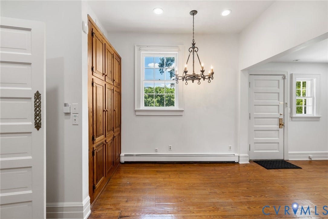 Hardwood flooring, recessed lighting, built-in wood cabinetry, white five-panel doors, and a wrought iron chandelier