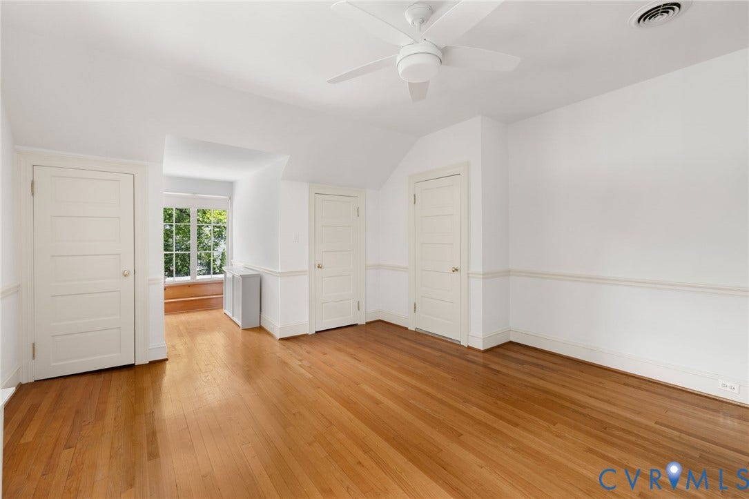 Hardwood flooring, painted paneled doors, ceiling fan, and a window seat with a multi-pane window