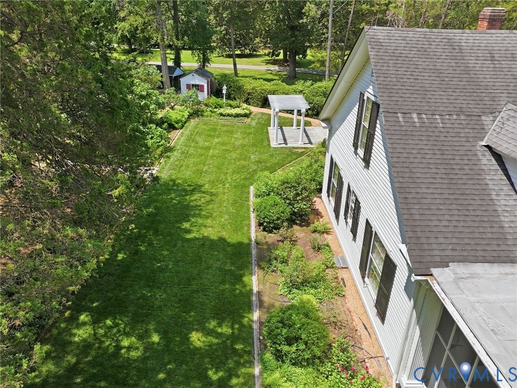 Expansive lawn area, white siding exterior, dark window shutters, asphalt shingle roof, and a freestanding gazebo