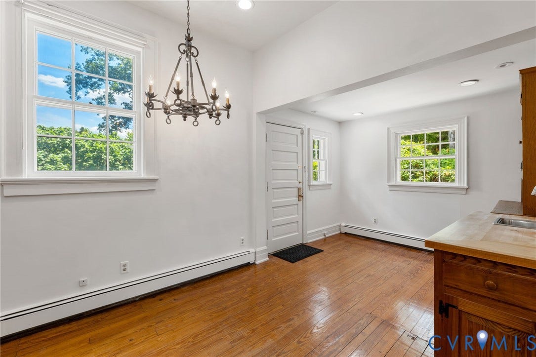 Wood-finish flooring, white walls, multiple windows, a wrought iron chandelier, and recessed lighting