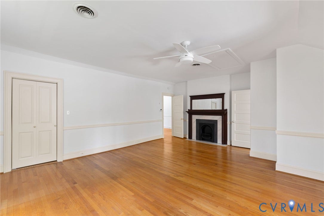 Hardwood flooring, crown molding, chair rail molding, ceiling fan, and a fireplace with wood mantel