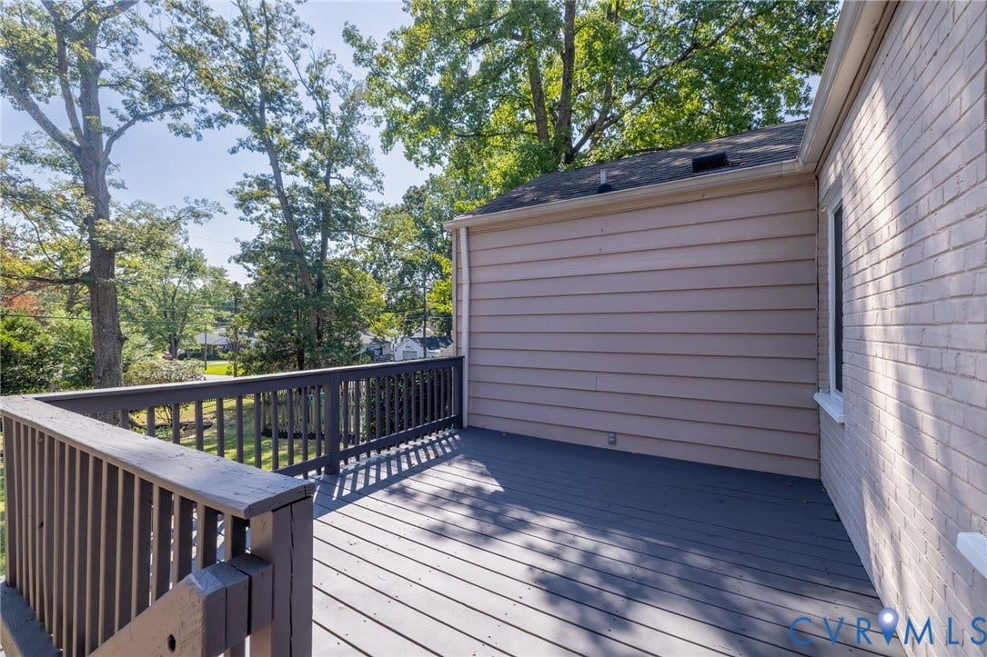 8415 Holly Hill Road, Henrico, VA 23229 Expansive outdoor deck with wood railings, a horizontal siding exterior, and a painted brick facade