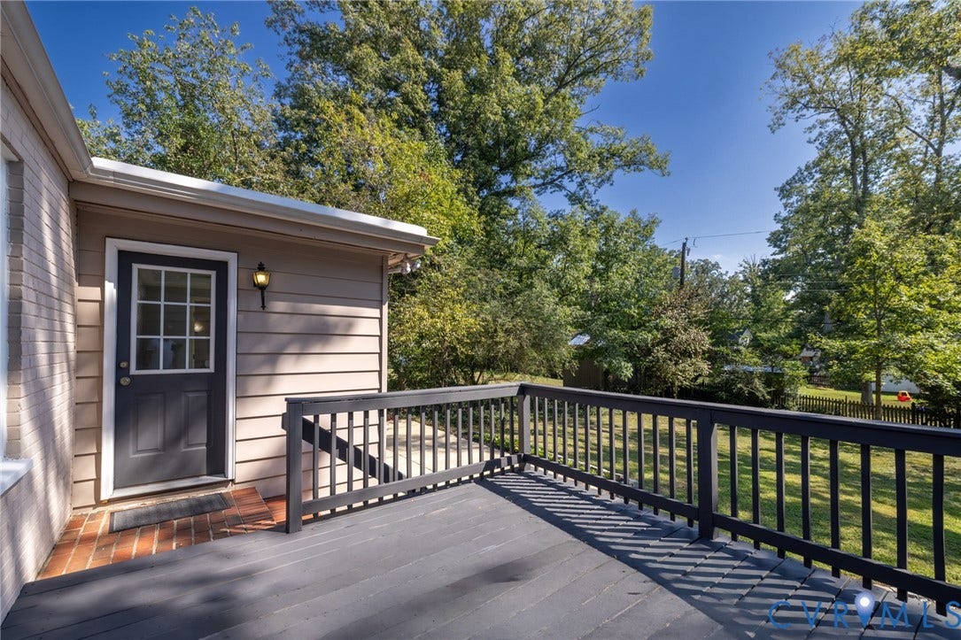 8415 Holly Hill Road, Henrico, VA 23229 Expansive outdoor deck with dark railing, offering a brick landing and a door with divided lites