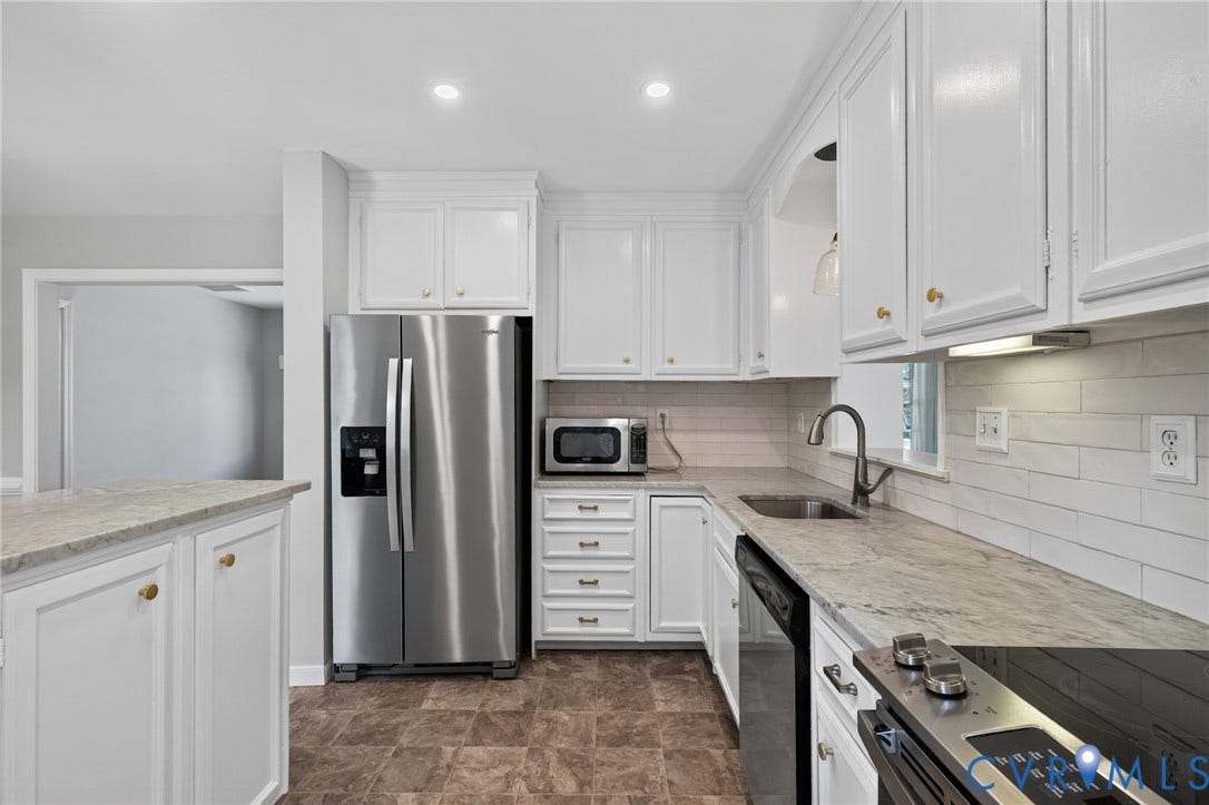 8415 Holly Hill Road, Henrico, VA 23229 White shaker-style cabinetry with gold-tone hardware, stainless steel appliances, light-toned countertop, and a subway tile backsplash