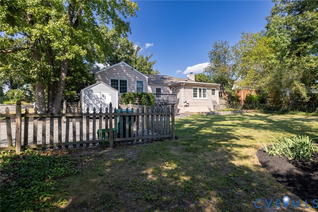8415 Holly Hill Road, Henrico, VA 23229 Expansive backyard with a manicured lawn, established trees, and a picket fence