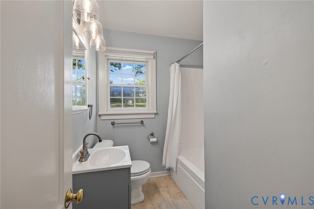 8415 Holly Hill Road, Henrico, VA 23229 Modern vanity with integrated sink, brushed nickel faucet, and overhead three-bulb vanity light