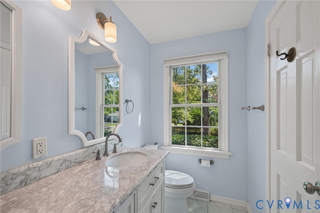 8415 Holly Hill Road, Henrico, VA 23229 White wood-framed vanity with a built-in sink, stone countertop, and dark-finish faucet