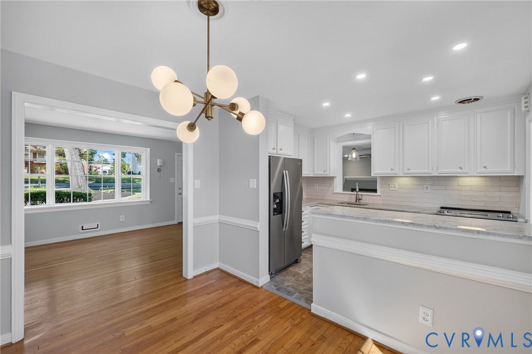 8415 Holly Hill Road, Henrico, VA 23229 Modern chandelier, wood-finish flooring, white cabinetry, integrated stainless steel appliances, and recessed lighting
