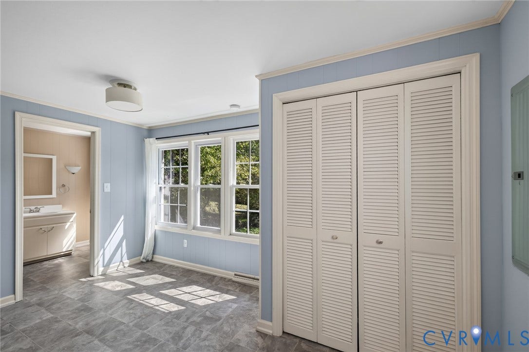 8415 Holly Hill Road, Henrico, VA 23229 Recessed windows with grid patterns, louvered bi-fold closet doors, wall paneling, and a flush mount ceiling fixture