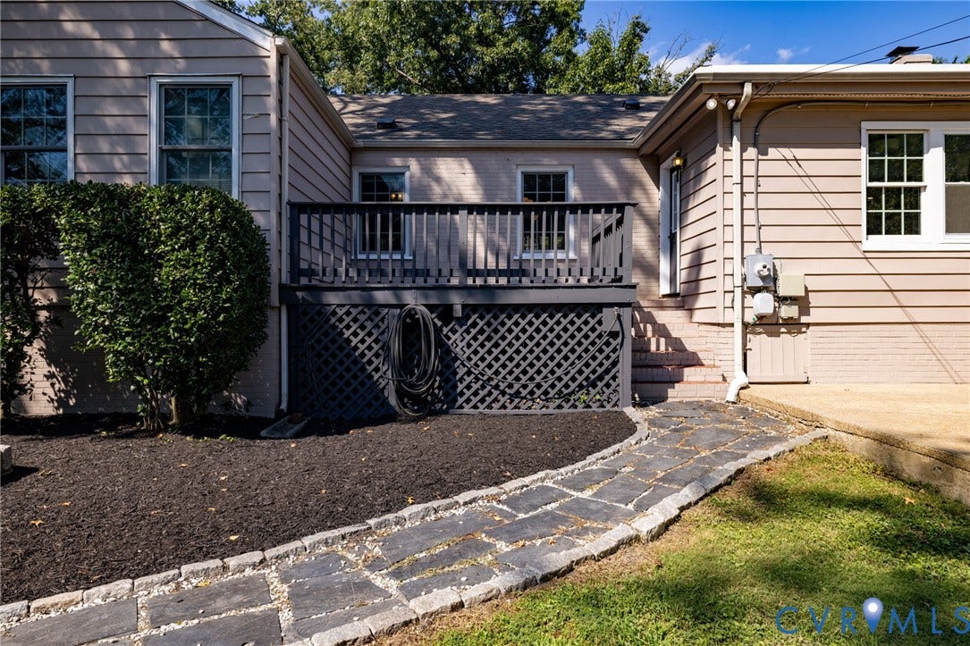 8415 Holly Hill Road, Henrico, VA 23229 Elevated wood deck with lattice skirting, stone paver pathway, and manicured landscaping