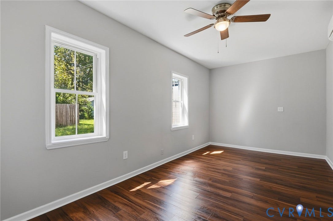 Wood-finish flooring, light gray wall tones, and multiple windows