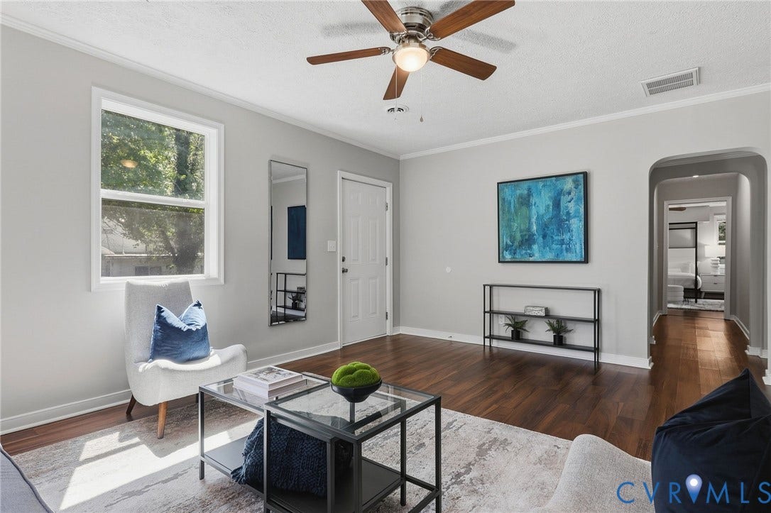 Hardwood-finish flooring, ceiling fan with integrated lighting, a single pane window, and an arched entryway