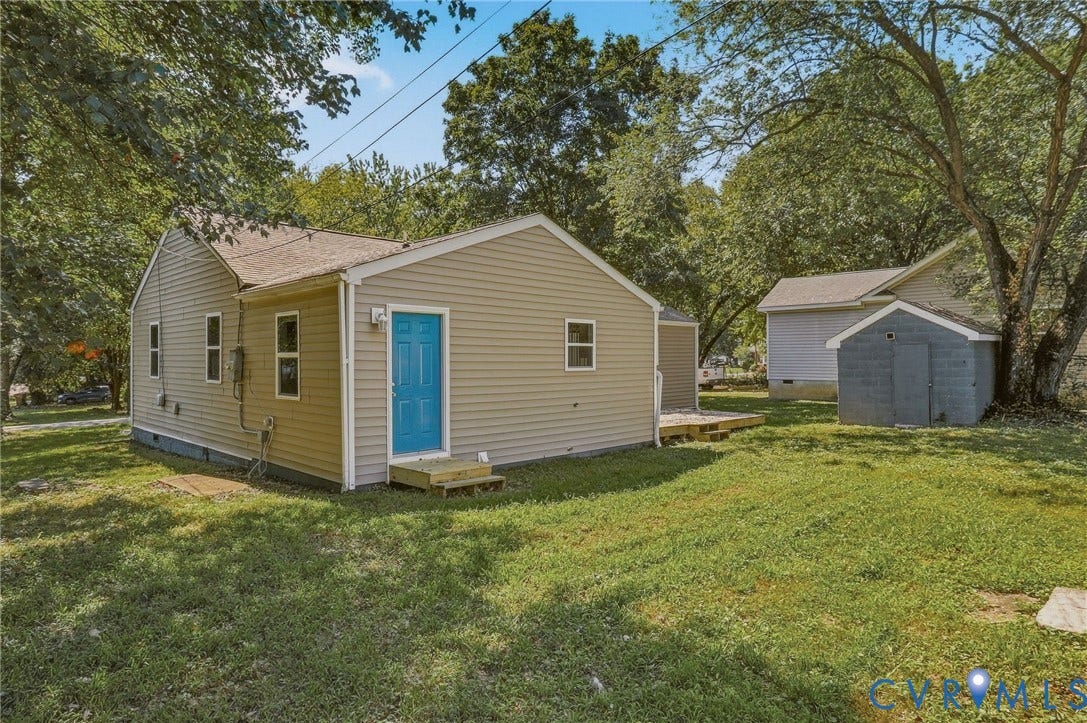 Tan vinyl siding exterior with a bright blue door