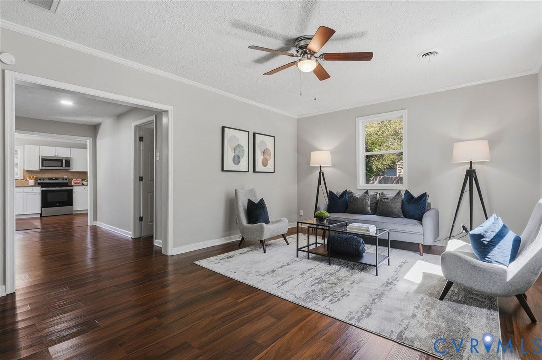Wood-finish flooring throughout, light gray wall paint, and a ceiling fan with integrated lighting