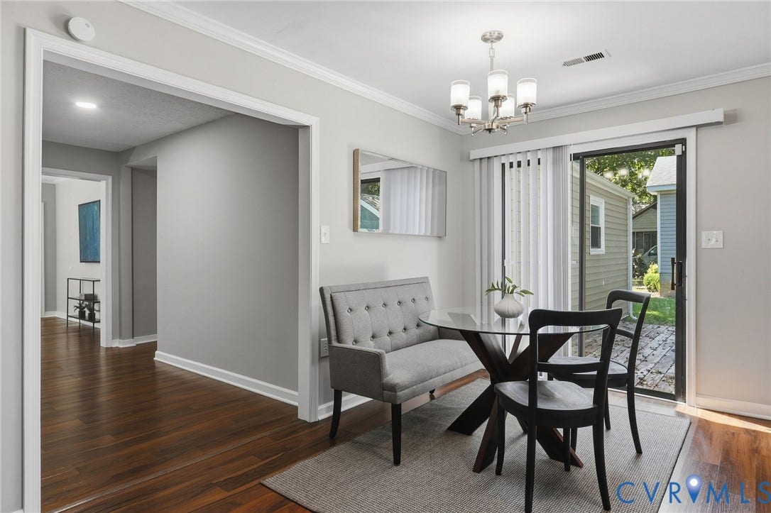 Wood-finish flooring, crown molding, brushed nickel chandelier, and a sliding glass door to the exterior