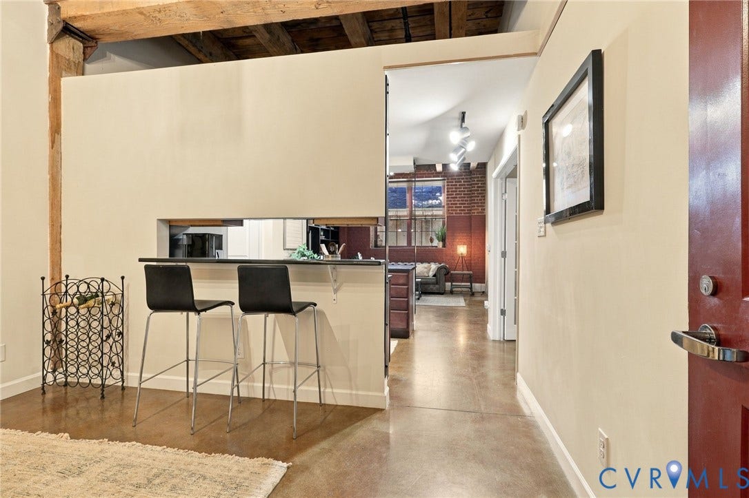 815 Porter Street, #U106, Manchester, Richmond, VA 23224 Exposed wood beam ceiling and polished concrete flooring extend throughout the home.