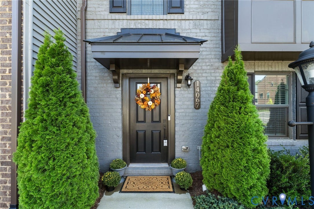 Brick exterior entrance with contrasting siding, and beautiful maintenance free landscaping.