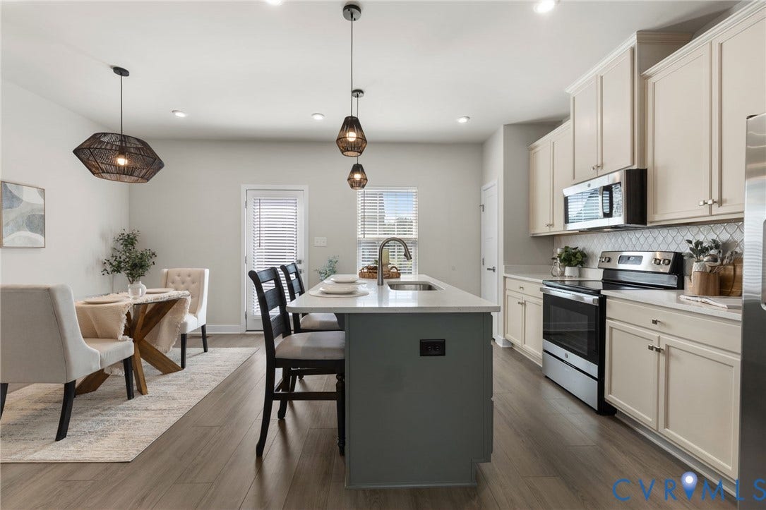 Open-concept living space with wood-finish flooring, recessed lighting, and kitchen island with quartz countertops