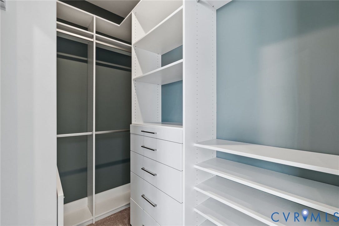 Custom built-in closet system with adjustable shelving, integrated drawers featuring polished hardware