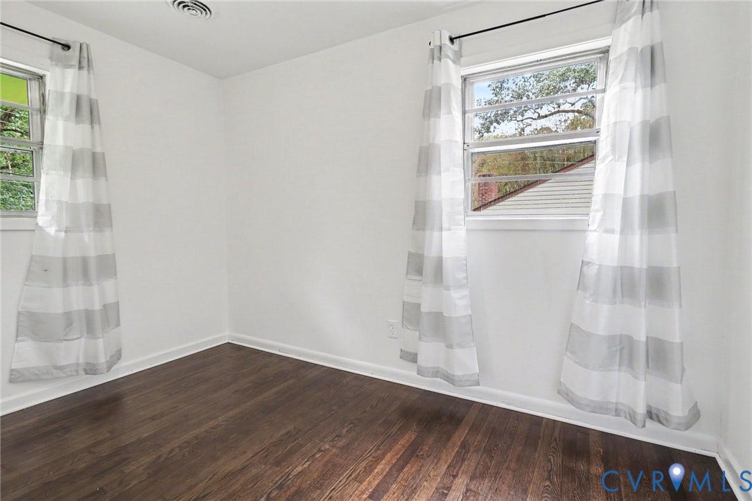 Hardwood flooring, white walls, and multiple windows