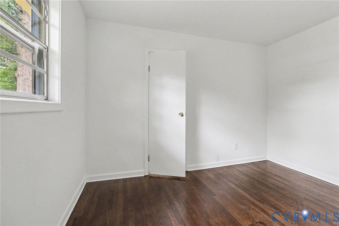 Wood-finish flooring, white walls, and a casement window