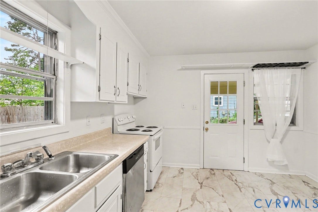 Kitchen featuring white cabinetry, a dual-basin stainless steel sink, and white appliances