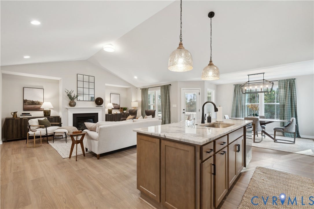 535 Wendenburg Terrace, #MODEL, Kennington, Aylett, VA 23009 Open-concept living area featuring a vaulted ceiling, wood-finish flooring, and a fireplace with a white mantel