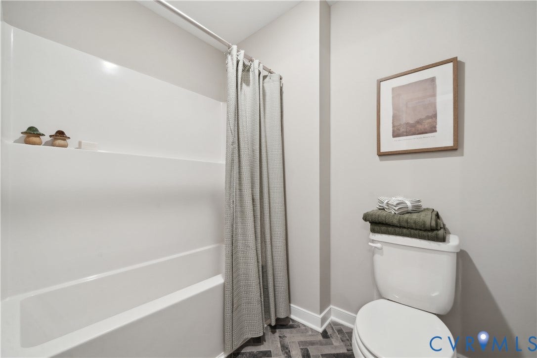 535 Wendenburg Terrace, #MODEL, Kennington, Aylett, VA 23009 Shower-over-tub combination with white acrylic surround, herringbone-patterned floor tiling, and a standard toilet