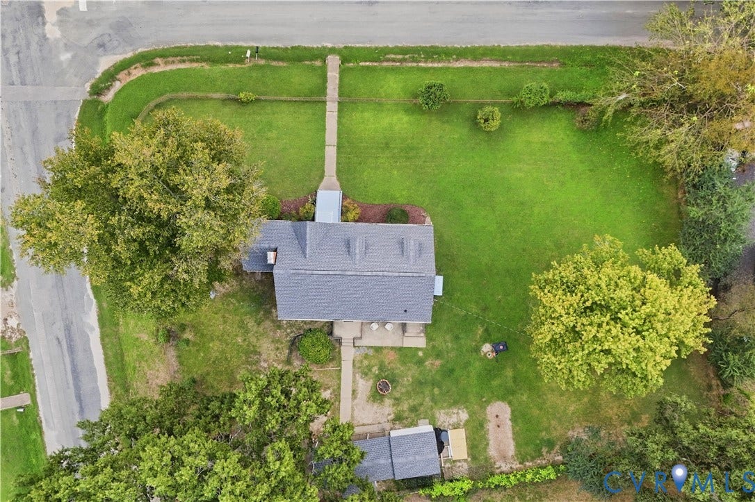 Expansive lot with lush green lawn, mature trees, and a paved walkway