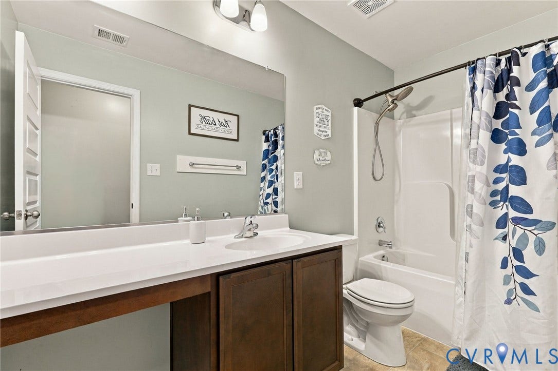 Full hall bath features a spacious vanity and tub/shower combination