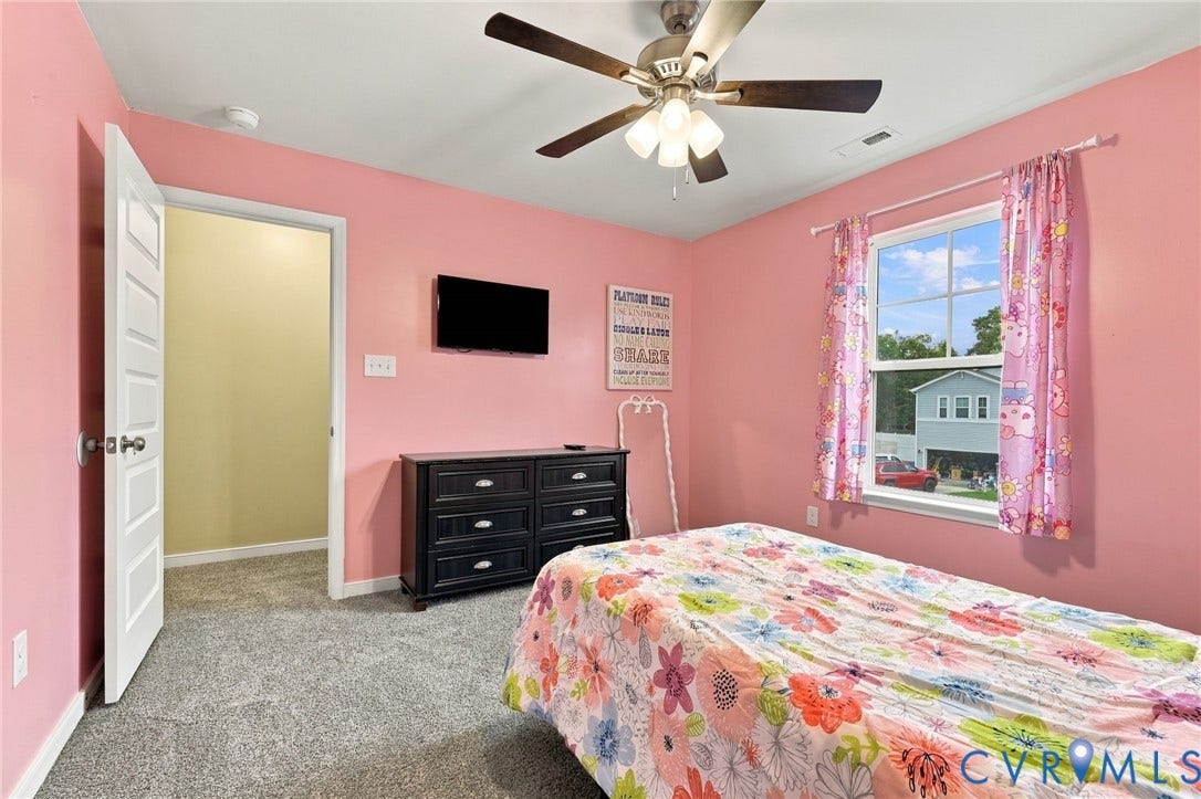 Bright secondary bedroom with new plush carpeting, ceiling fan, and its own walk-in closet.