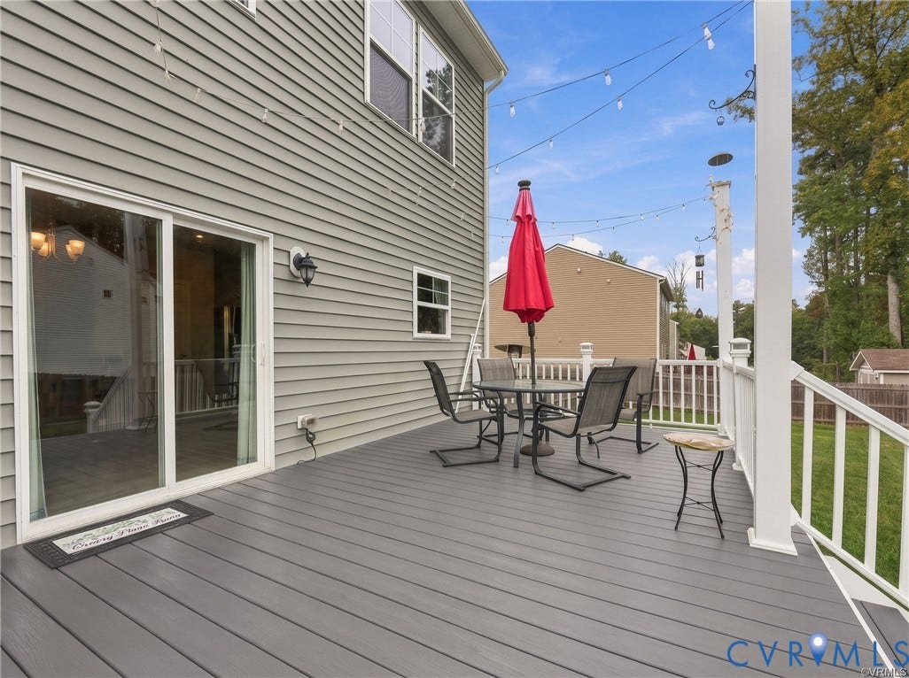 Expansive composite deck offers plenty of space for lounging and entertaining, overlooking the fenced backyard.