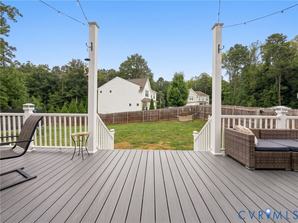 View from the deck showcases the level, fenced backyard with plenty of room for outdoor activities.