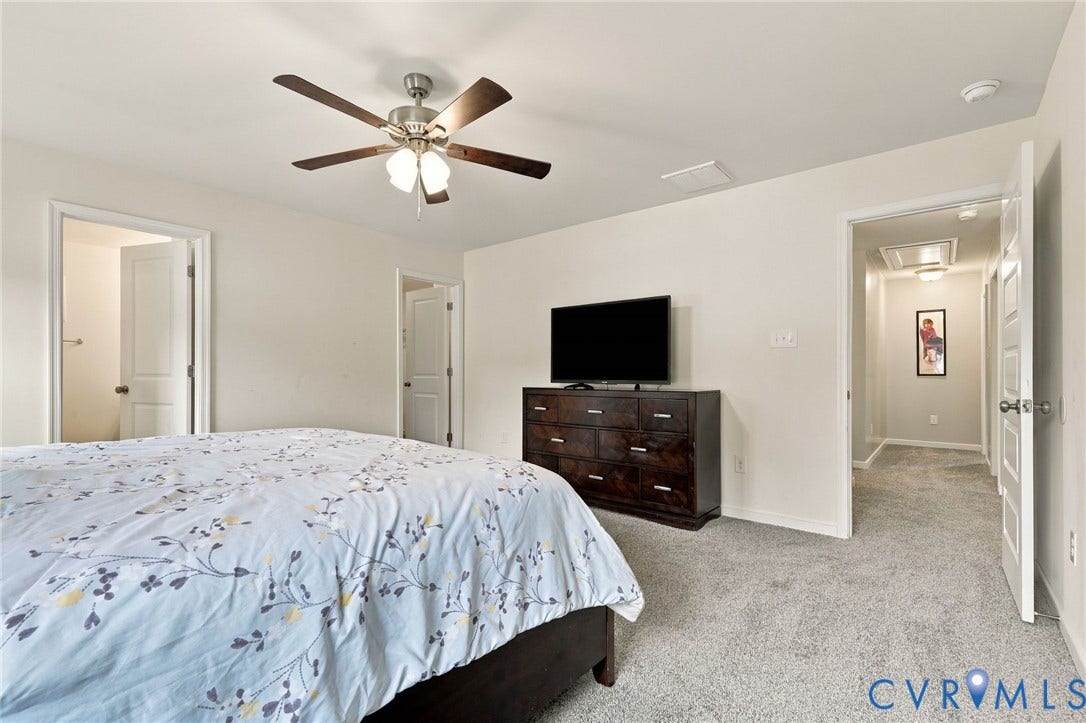 Another view of the spacious primary suite, offering plenty of room for additional furnishings and large walk in closet.
