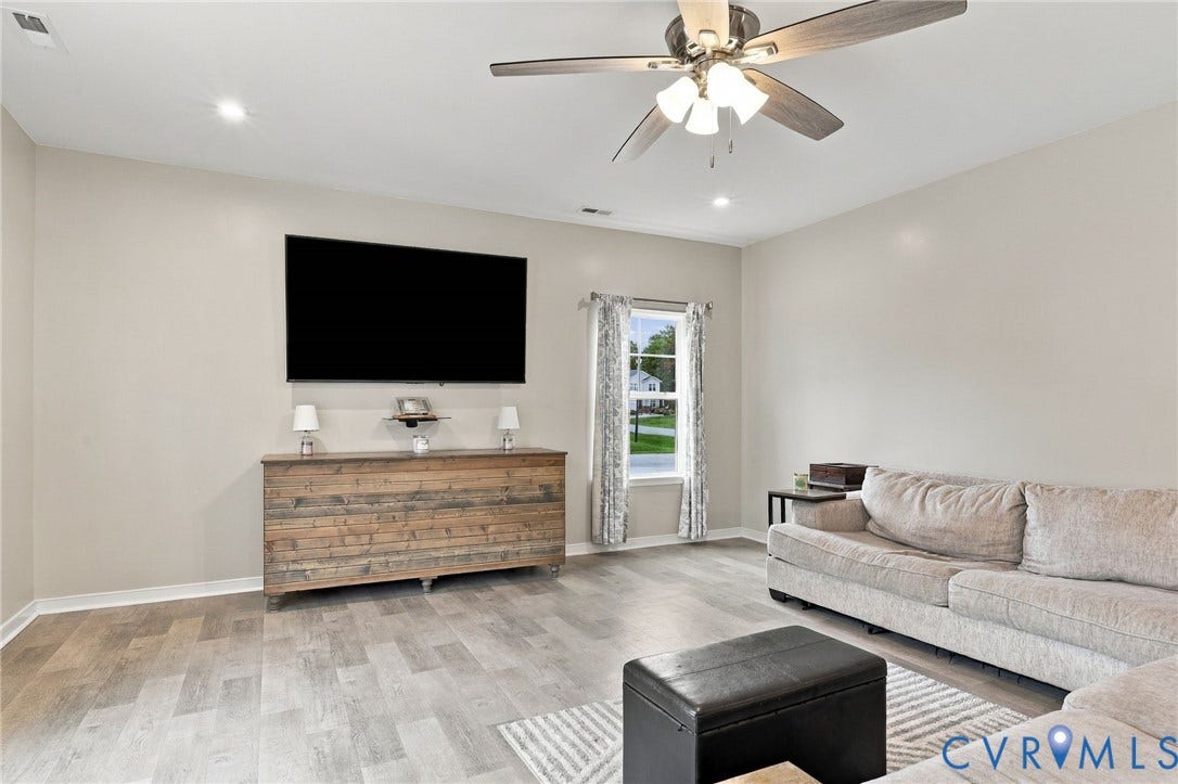 Spacious family room offers plenty of room to gather with recessed lighting, a ceiling fan, and durable flooring.