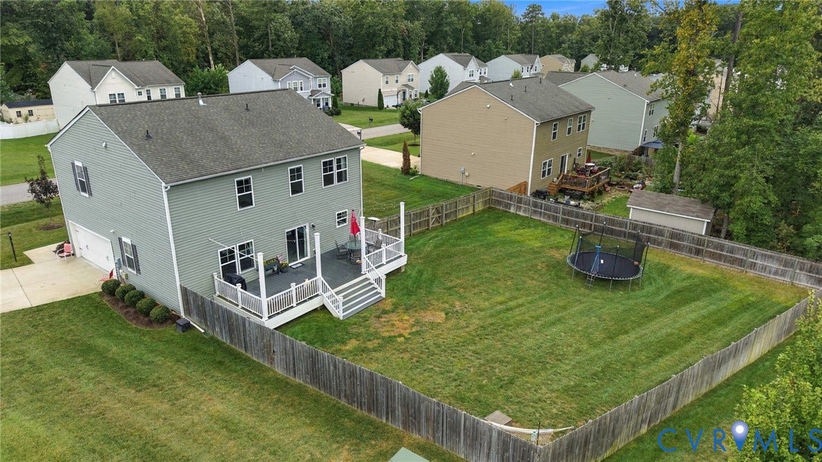 Aerial view highlights the spacious fenced backyard, expansive deck, and generous outdoor living space.