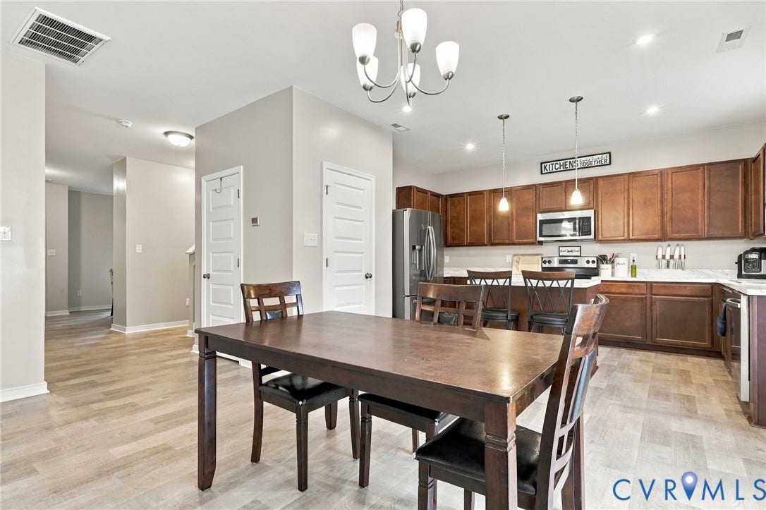 Door to left of refrigerator is pantry and door by stairs offers generous sized coat closet.