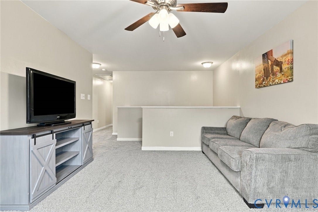 Another view of the generous loft with overhead lighting, neutral paint and brand new carpet.