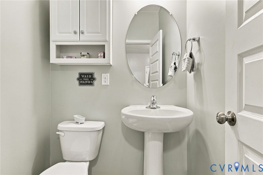 Convenient main-level powder room with pedestal sink and additional storage.