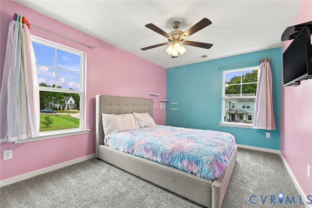 Bright and spacious bedroom 4 featuring two windows, ceiling fan, and plenty of natural light.