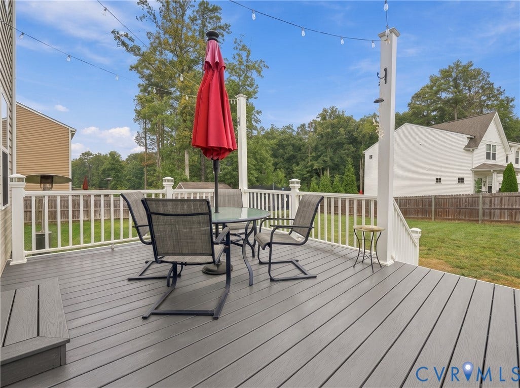 Spacious outdoor dining area with string lights creates a welcoming setting for meals and gatherings.