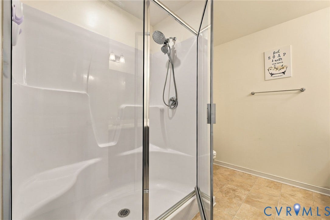 Primary en-suite features a shower with glass enclosure and handheld showerhead.