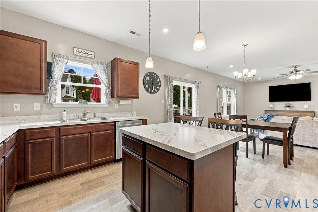 Open sightlines from the kitchen into the dining and family rooms highlight the homes spacious and connected main-level design.