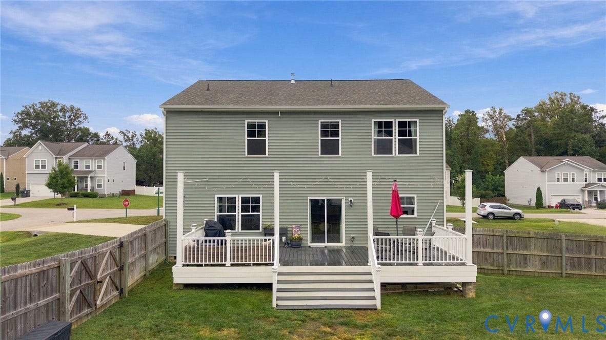 Full rear view highlights the expansive deck with multiple seating areas and easy access to the backyard.