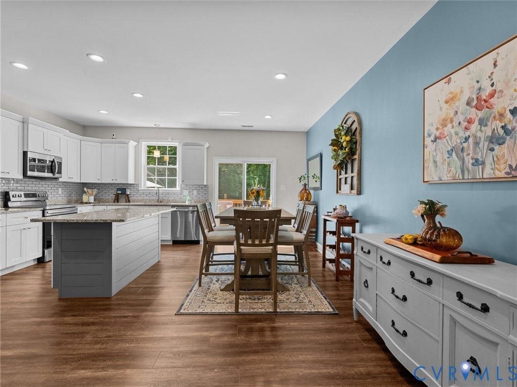 5927 Trenholm Village Drive, Trenholm Village, Powhatan, VA 23139 Kitchen featuring stainless steel appliances, white cabinetry, a tile backsplash, and an island with a countertop