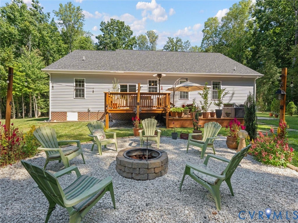 5927 Trenholm Village Drive, Trenholm Village, Powhatan, VA 23139 Rear exterior featuring a wood deck, stone fire pit, and gravel patio area