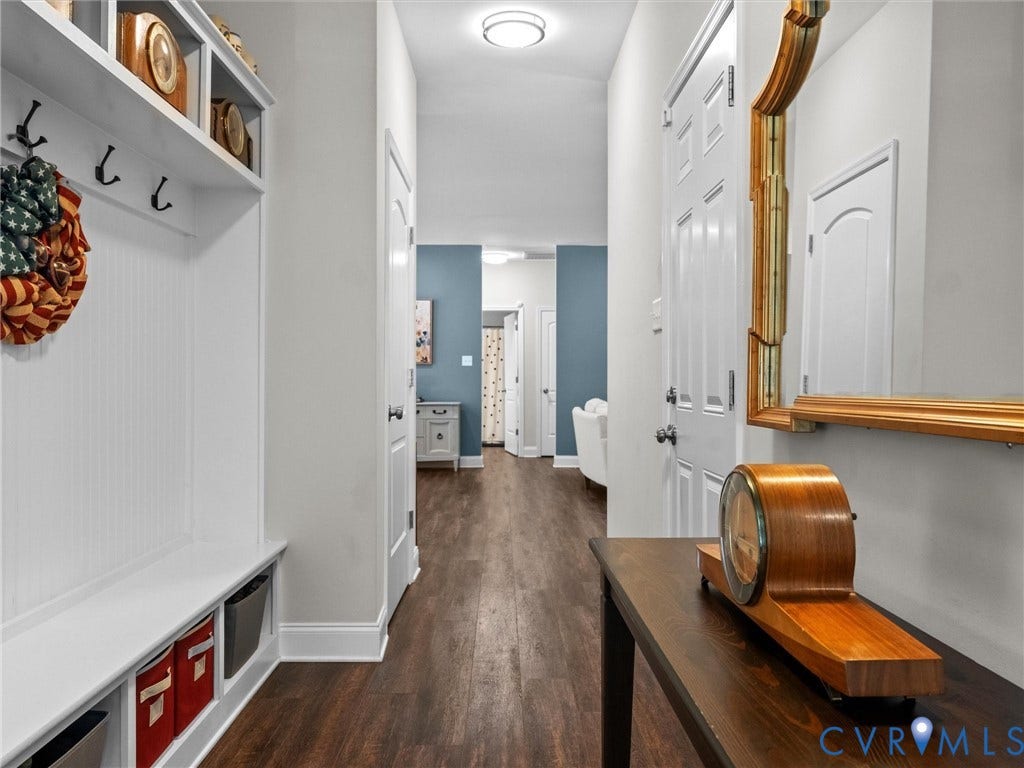 5927 Trenholm Village Drive, Trenholm Village, Powhatan, VA 23139 Hallway featuring wood-finish flooring, a built-in white mudroom bench with storage cubbies, and a decorative wall mirror