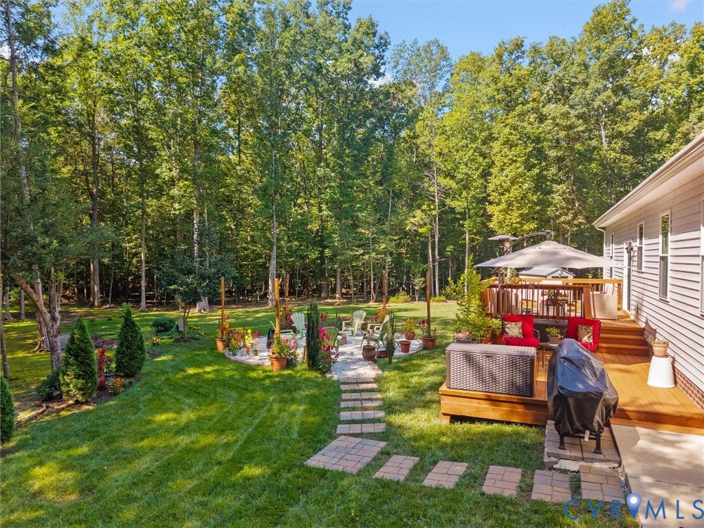 5927 Trenholm Village Drive, Trenholm Village, Powhatan, VA 23139 Expansive backyard with a manicured lawn, stone pathway, and mature trees